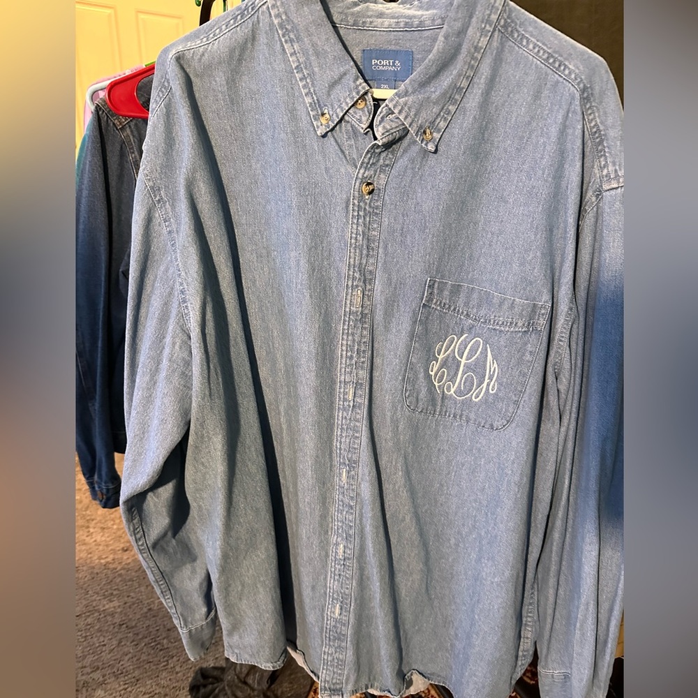Denim shirt with llm embroidered on front chest pocket.